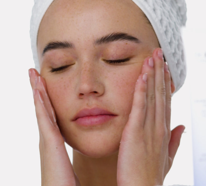 a woman with her eyes closed touching her face